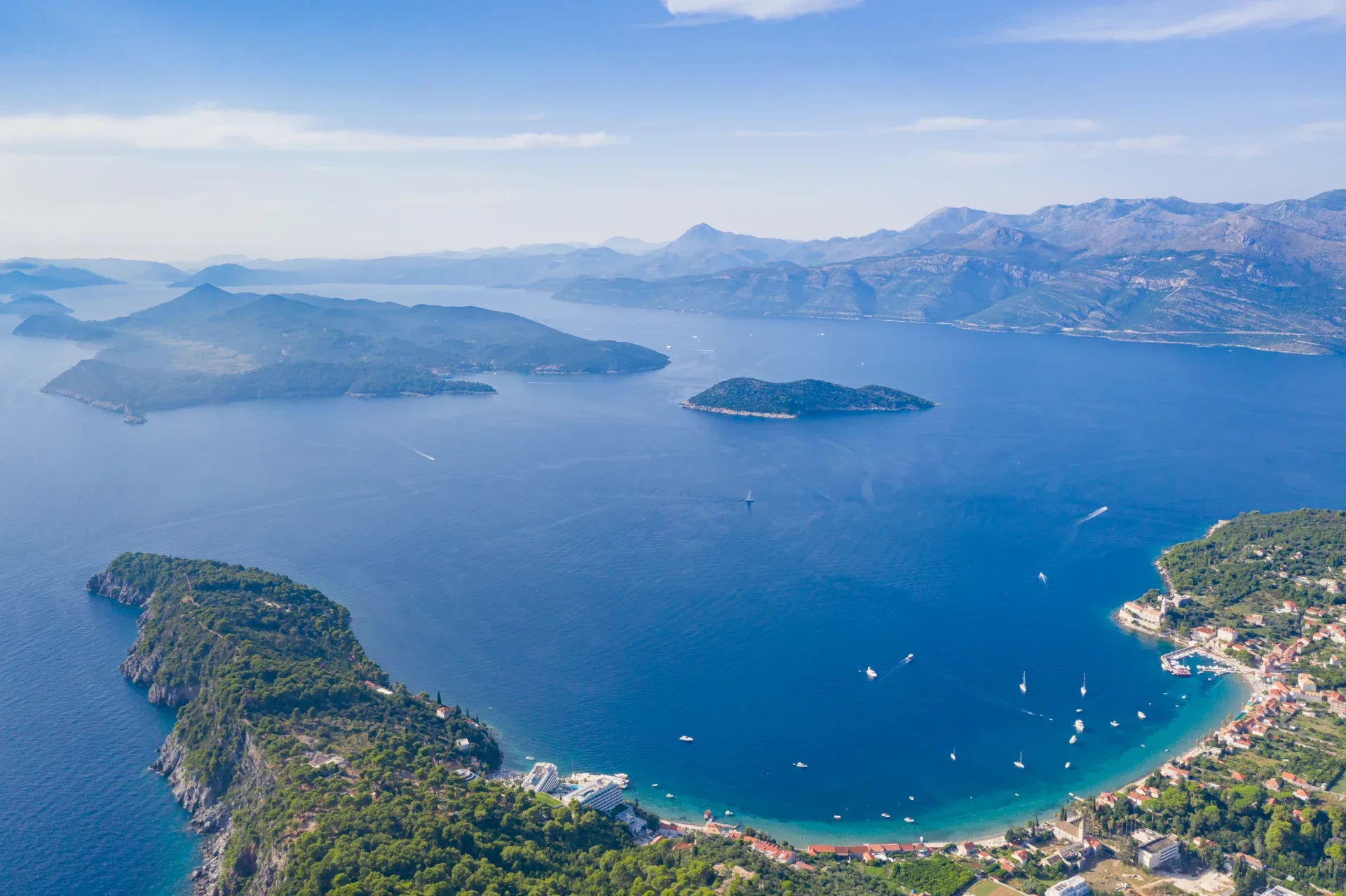 Lopuds beboede bugt set fra luften med de nærliggende øer og den dalmatiske kyst i baggrunden.