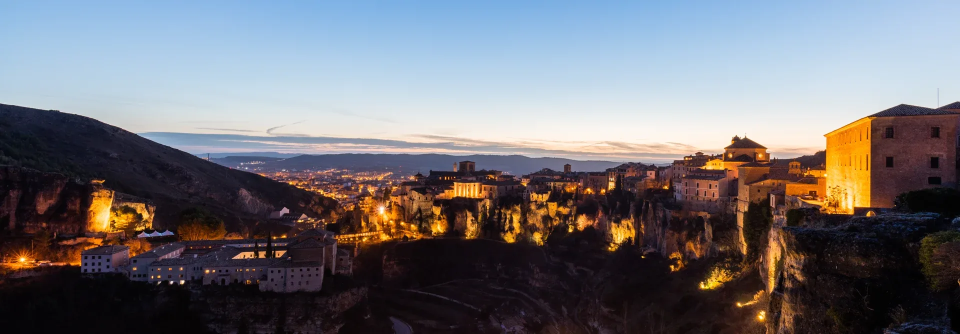 La ville ancienne de Cuenca et les falaises de la gorge du Huécar éclairées au crépuscule.