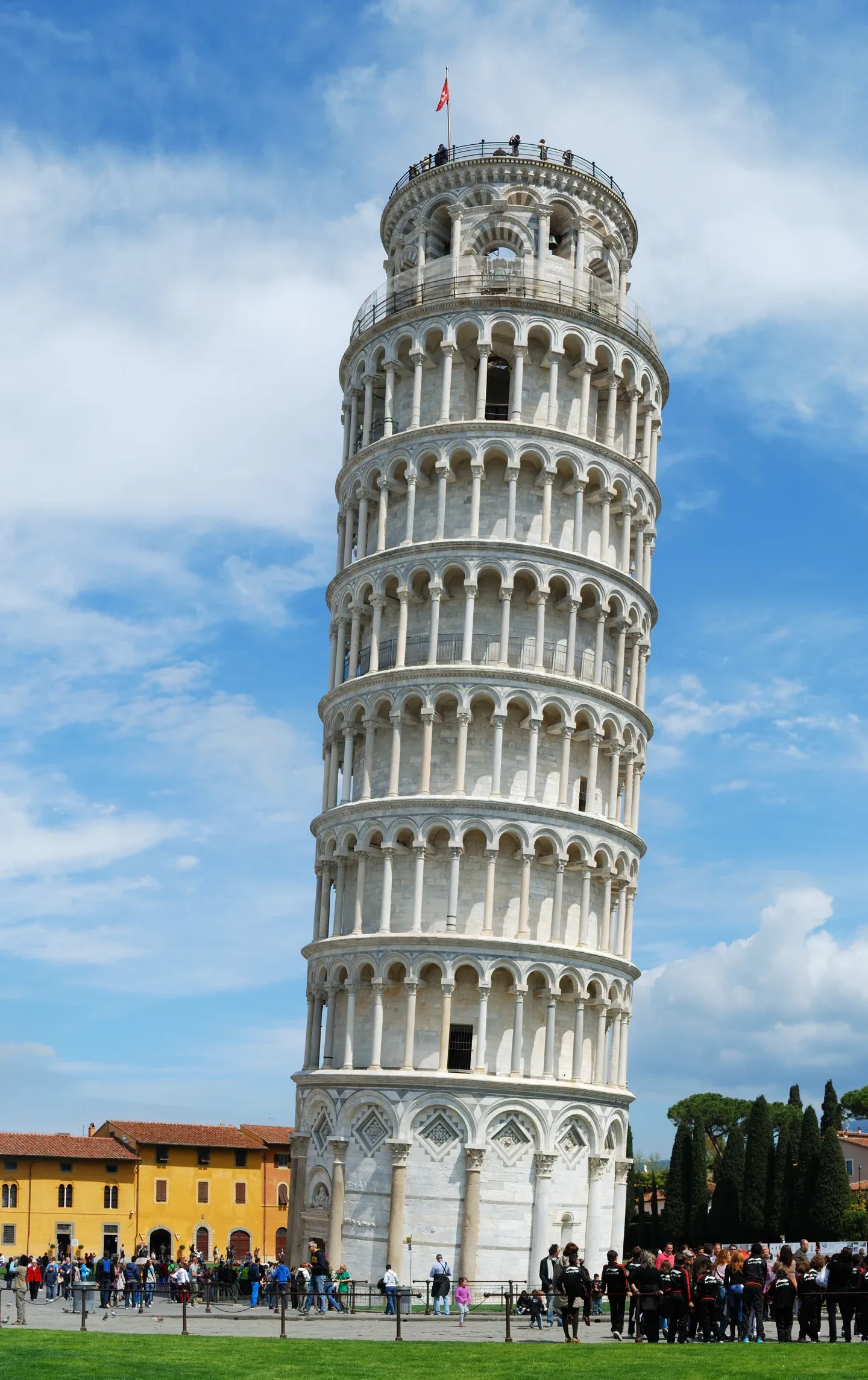 Det skæve tårn i Pisa med sine marmorarkader og besøgende ved foden.