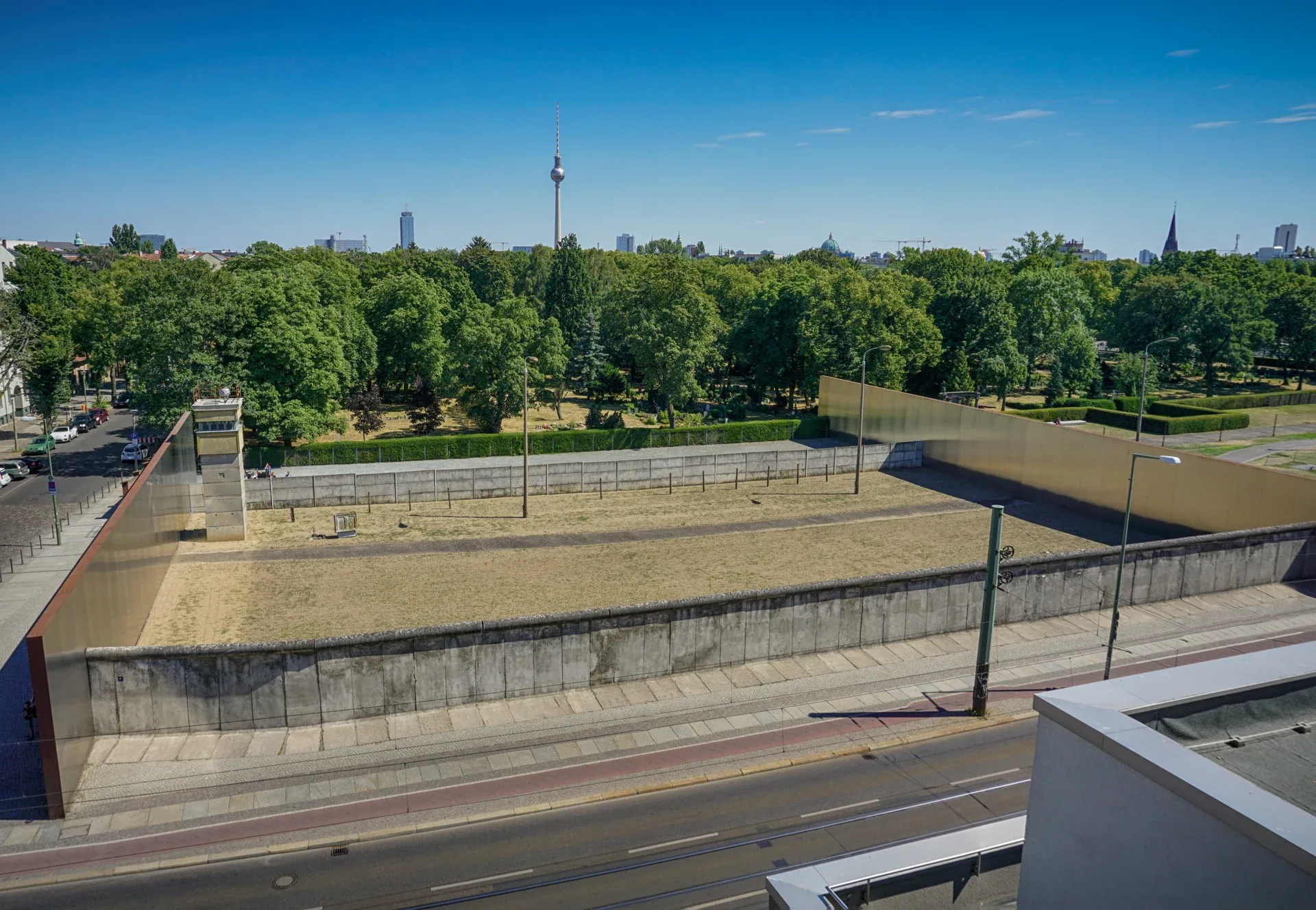 To vegger, et vakttårn og en grensestripe ved minnesmerket i Bernauer Strasse i Berlin.