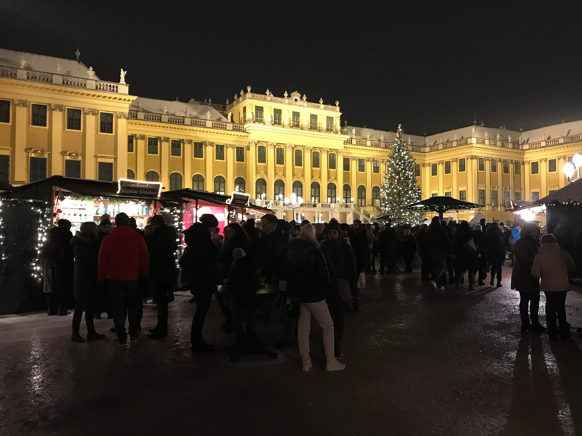 Chalets, visiteurs et grand sapin dans la cour du palais de Schönbrunn, photographiés en décembre 2018.