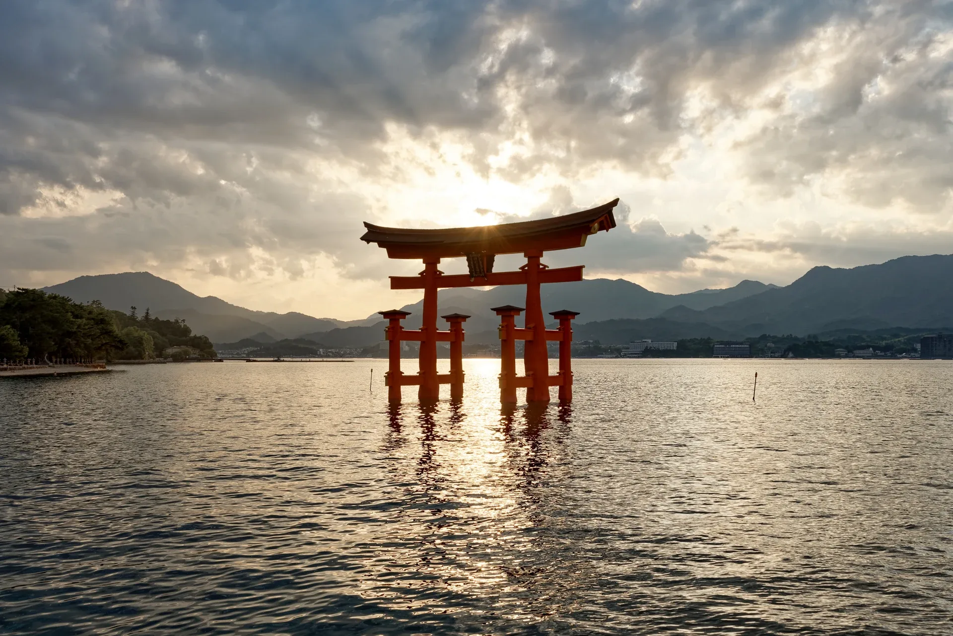 Den store torii-porten ved Itsukushima i vannet ved solnedgang på Miyajima.
